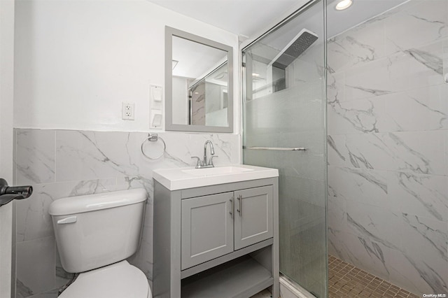 bathroom featuring vanity, toilet, tile walls, and a tile shower