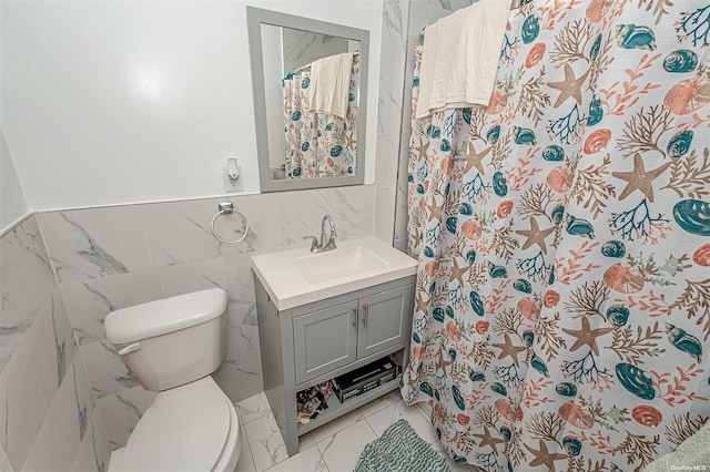 bathroom with curtained shower, vanity, tile walls, and toilet