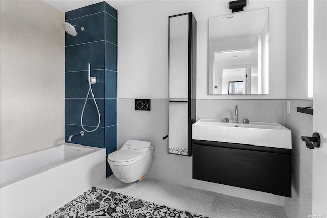 full bathroom featuring vanity, tile patterned floors, tiled shower / bath combo, toilet, and tile walls