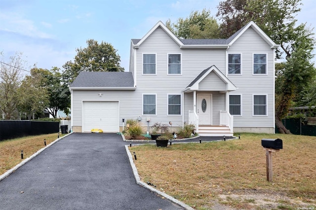 view of front of property featuring a front yard and a garage