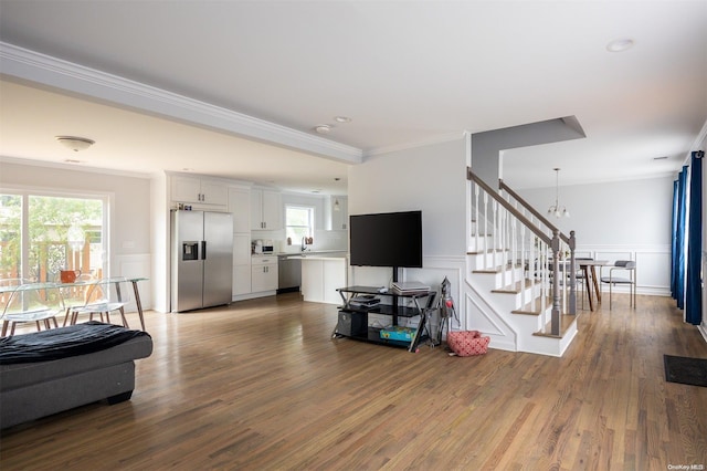 living room featuring ornamental molding, a notable chandelier, and hardwood / wood-style flooring