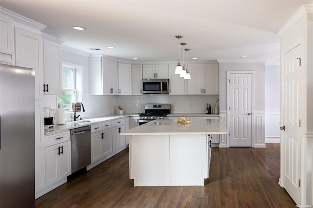 kitchen with white cabinetry, a center island, dark hardwood / wood-style floors, pendant lighting, and appliances with stainless steel finishes