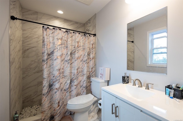 bathroom with toilet, vanity, and walk in shower