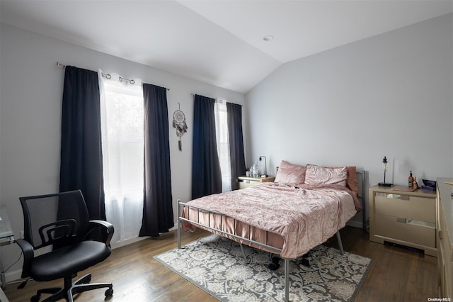 bedroom with hardwood / wood-style flooring, vaulted ceiling, and multiple windows