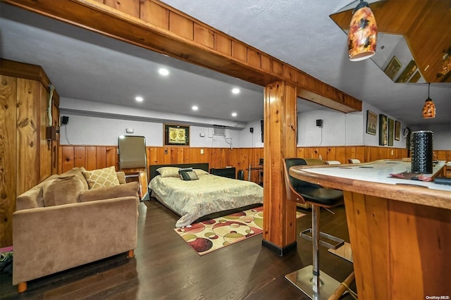 bedroom featuring dark hardwood / wood-style flooring and wooden walls