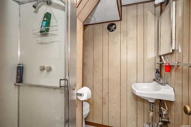 bathroom with toilet, wood walls, and an enclosed shower