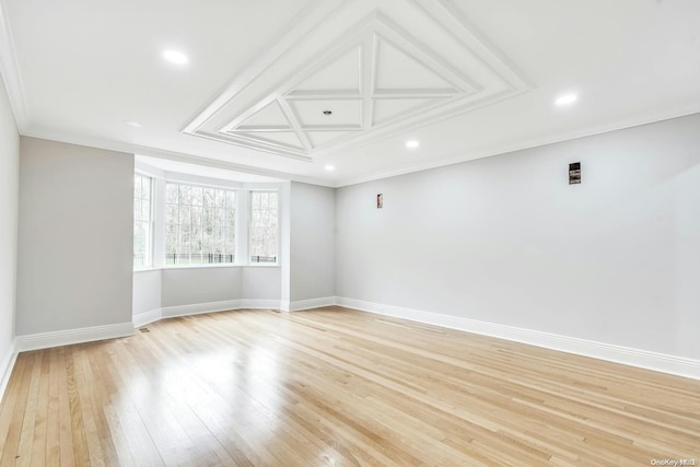 empty room with ornamental molding and light hardwood / wood-style flooring