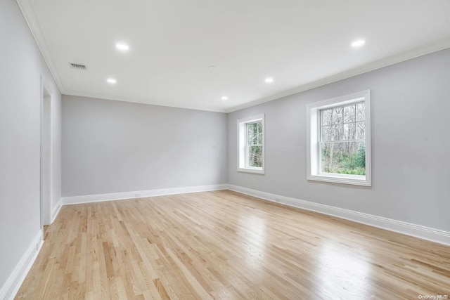 empty room with ornamental molding and light hardwood / wood-style flooring