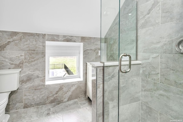 bathroom with toilet, tile walls, and a shower with shower door