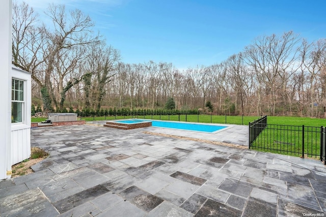 view of swimming pool featuring a patio, a hot tub, and a lawn