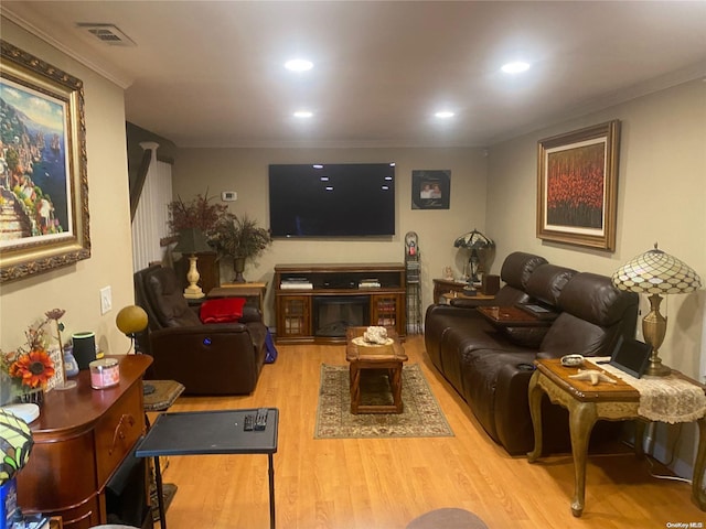 living room featuring light hardwood / wood-style flooring and ornamental molding