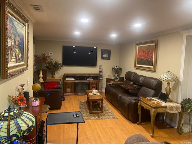 living room with hardwood / wood-style flooring and crown molding