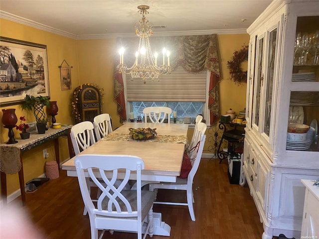 dining space with dark hardwood / wood-style flooring, an inviting chandelier, and ornamental molding