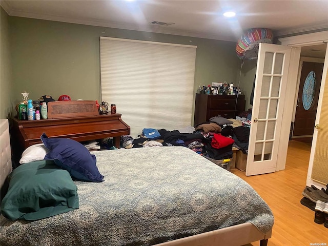 bedroom featuring wood-type flooring and ornamental molding