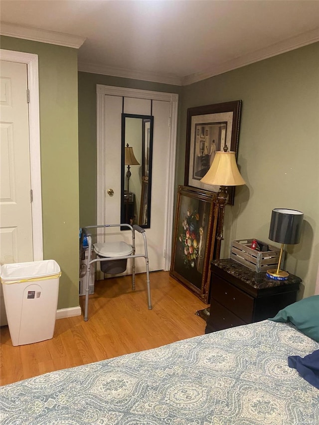 bedroom featuring a closet, crown molding, and light hardwood / wood-style flooring