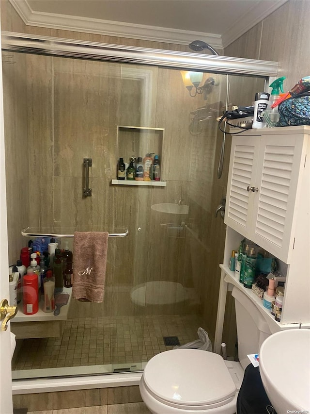 bathroom featuring toilet, a shower with shower door, crown molding, and sink