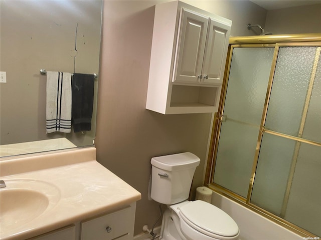 full bathroom featuring vanity, toilet, and bath / shower combo with glass door