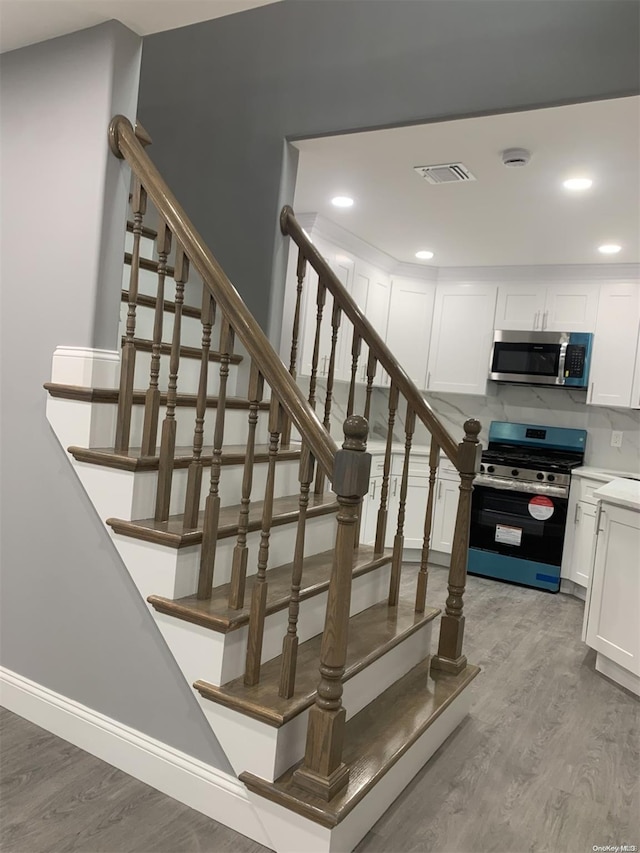 staircase with hardwood / wood-style flooring