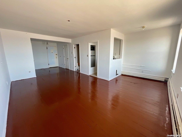 spare room with dark hardwood / wood-style floors and a baseboard radiator