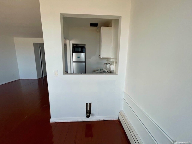 interior space featuring sink, dark wood-type flooring, and a baseboard radiator