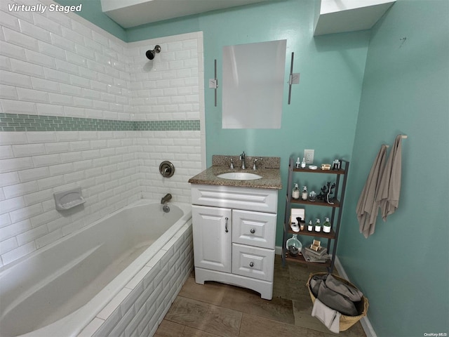 bathroom with tile patterned flooring, vanity, and a relaxing tiled tub