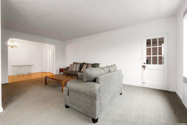 carpeted living room featuring radiator and a notable chandelier