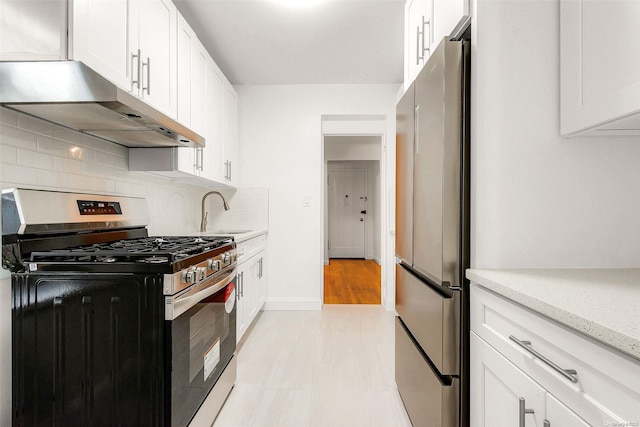 kitchen featuring tasteful backsplash, white cabinetry, sink, and appliances with stainless steel finishes