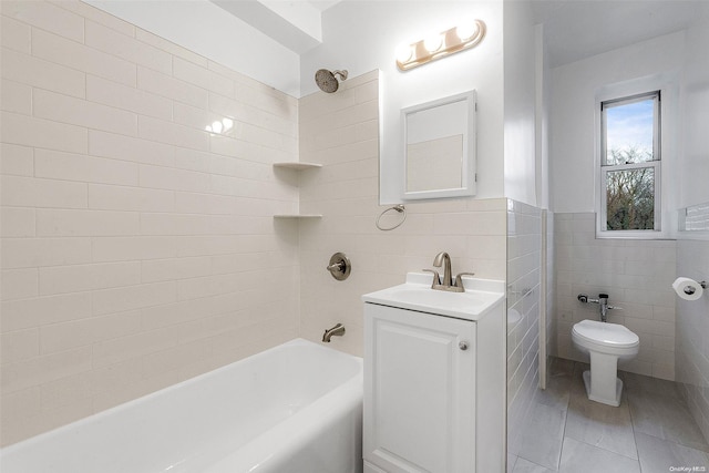 full bathroom with toilet, vanity, tile walls, and tiled shower / bath