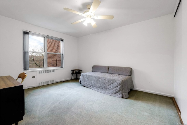 carpeted bedroom with radiator and ceiling fan