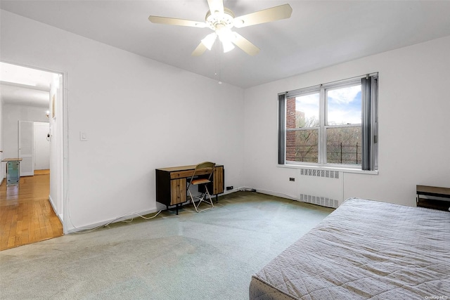 bedroom featuring radiator, ceiling fan, and light wood-type flooring