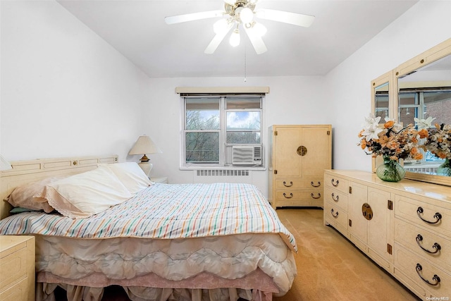 bedroom with radiator, light colored carpet, ceiling fan, and cooling unit