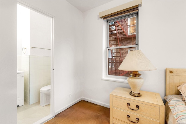 interior space with light tile patterned floors and ensuite bathroom