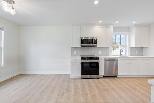 kitchen with appliances with stainless steel finishes, sink, and white cabinetry