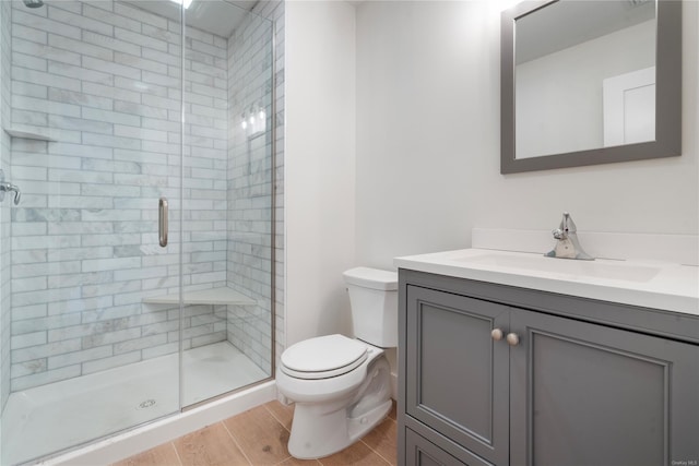 bathroom with toilet, vanity, and an enclosed shower