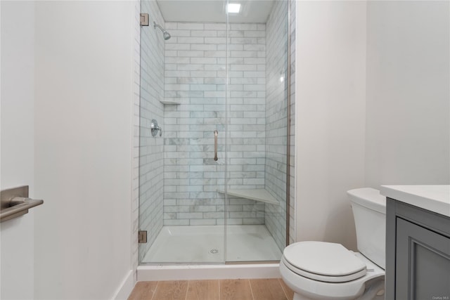 bathroom with a shower with door, wood-type flooring, toilet, and vanity