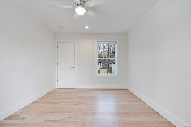 empty room with ceiling fan and light hardwood / wood-style flooring