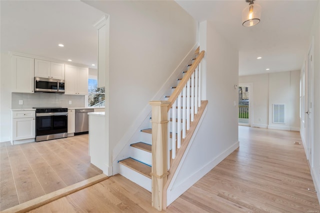 staircase with hardwood / wood-style flooring