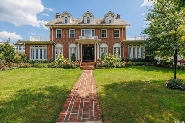 colonial-style house featuring a front lawn