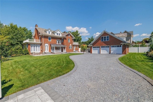 view of front of house featuring a garage, a balcony, and a front lawn