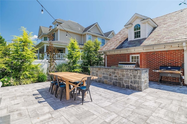 view of patio with area for grilling, sink, and an outdoor kitchen