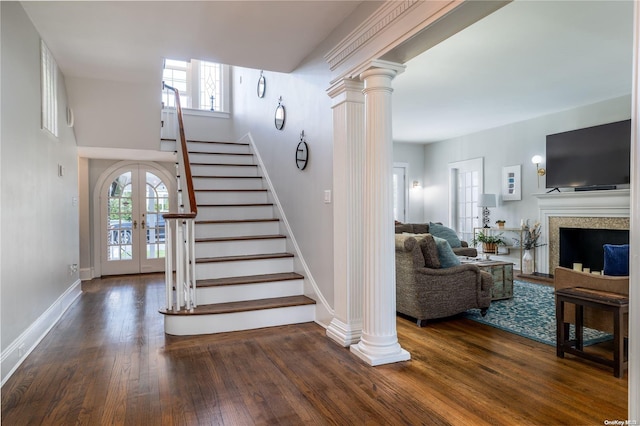 stairway with french doors, a healthy amount of sunlight, and wood-type flooring