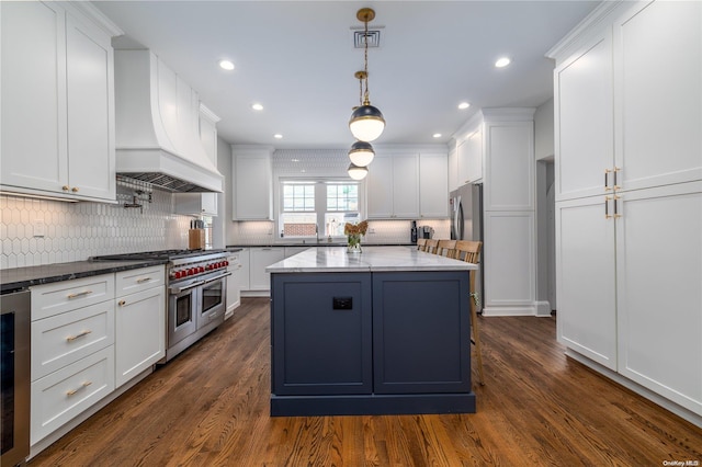 kitchen featuring custom range hood, dark hardwood / wood-style flooring, stainless steel appliances, and white cabinetry