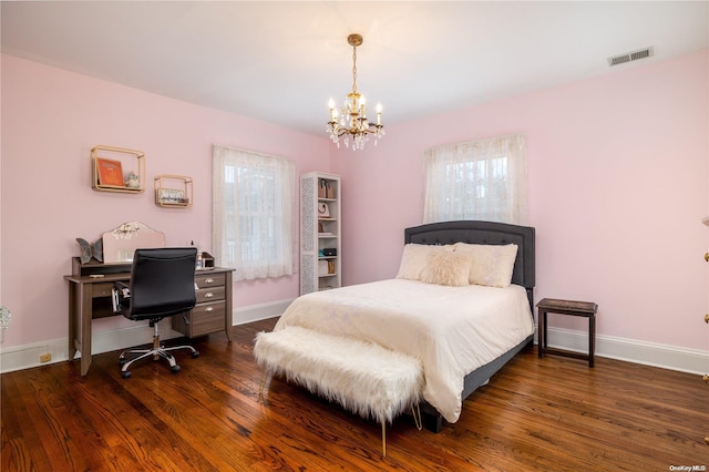 bedroom with dark hardwood / wood-style flooring and a chandelier