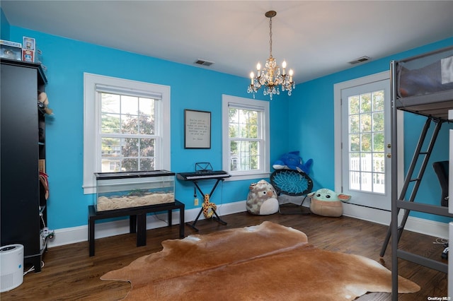 miscellaneous room with dark wood-type flooring, a wealth of natural light, and a chandelier