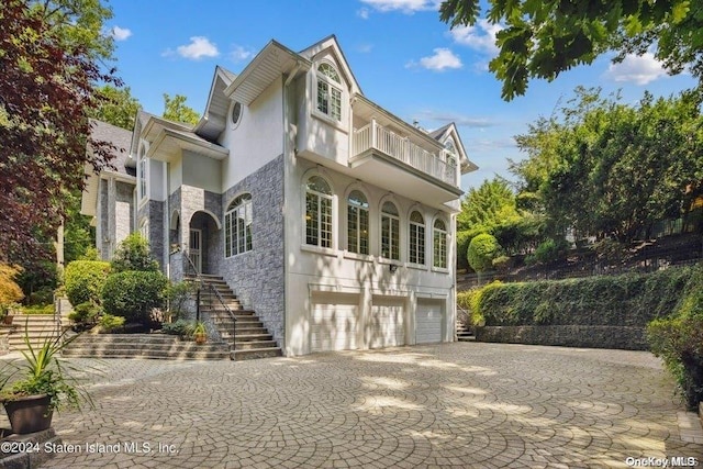 view of front of home with a garage and a balcony