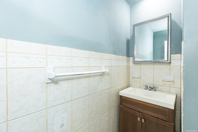 bathroom featuring vanity and tile walls