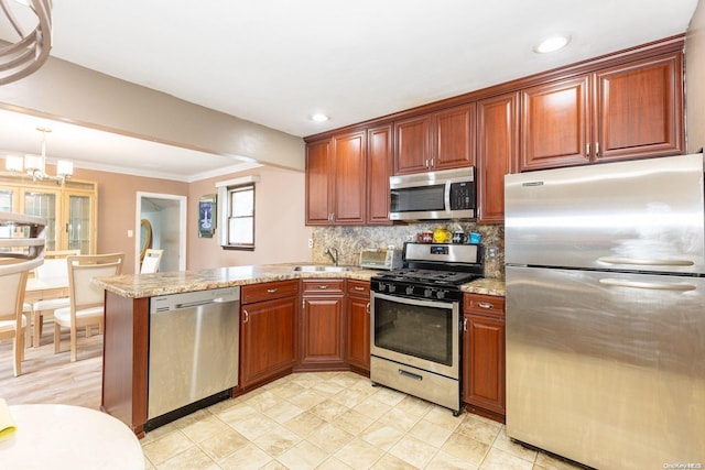 kitchen with sink, hanging light fixtures, stainless steel appliances, decorative backsplash, and kitchen peninsula