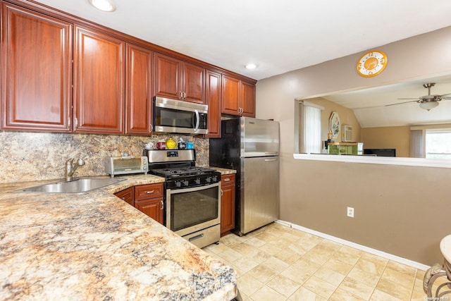 kitchen with tasteful backsplash, sink, light stone counters, ceiling fan, and stainless steel appliances