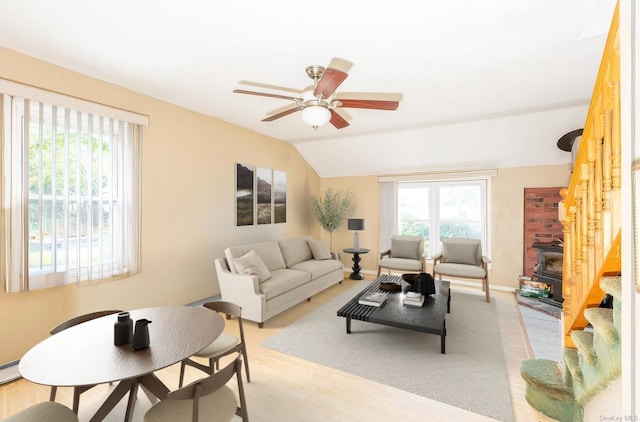 living room featuring ceiling fan, lofted ceiling, and light hardwood / wood-style flooring