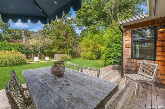 wooden deck featuring a lawn